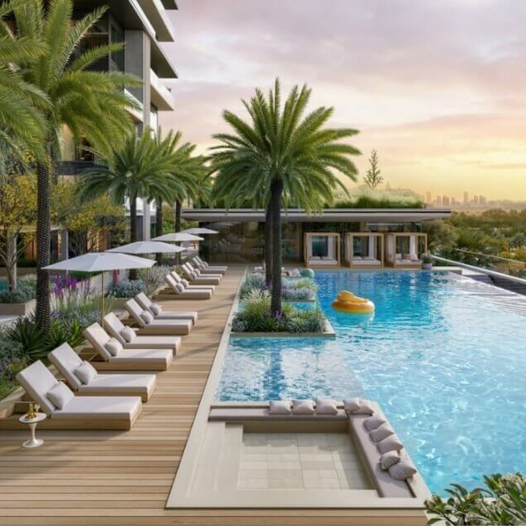 Pool deck at Al Yalayis by Ellington — sun loungers and parasols along a timber deck beside an infinity pool at sunset
