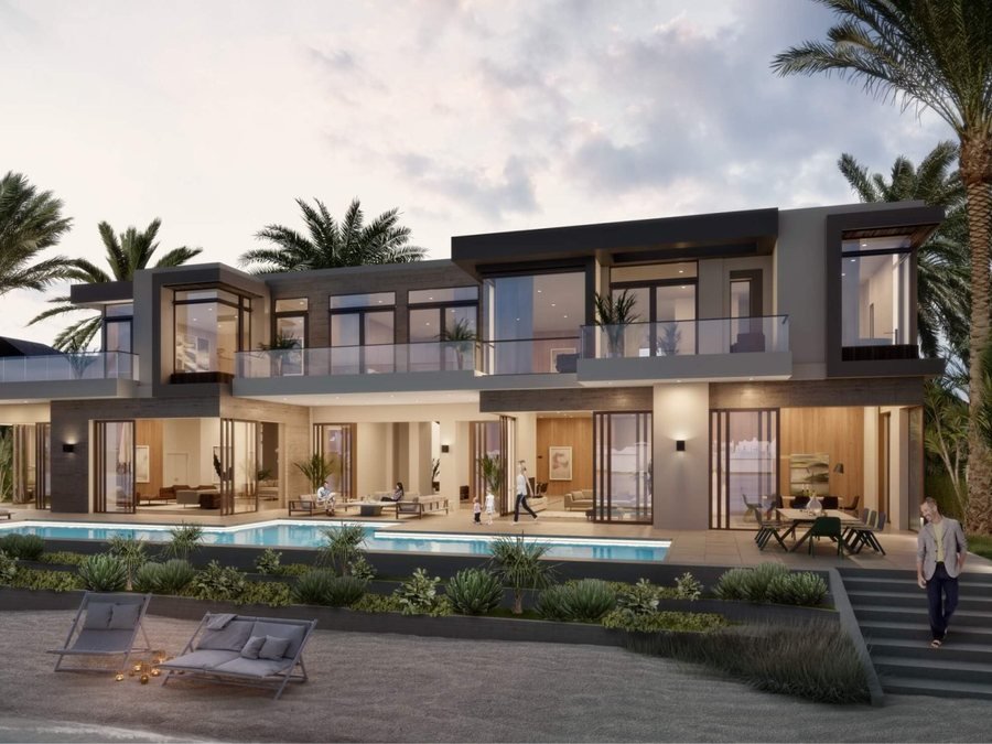 Villa at Al Yalayis by Ellington — a two-storey villa at dusk with full-height glazing, a wraparound terrace, private pool and mature palms